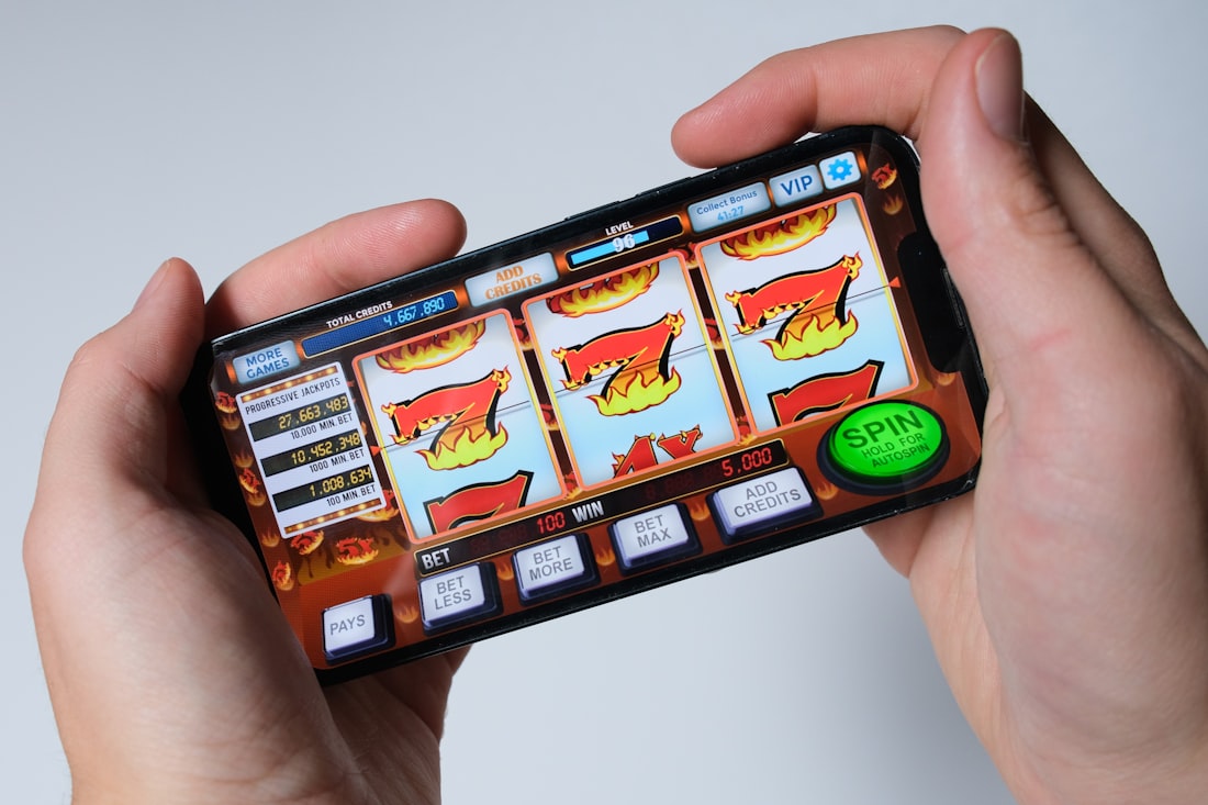 Tangan seseorang bermain permainan slot dari layar ponsel
