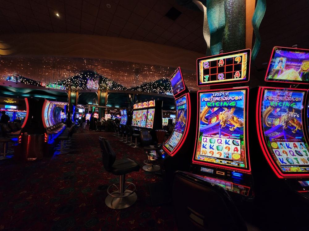 Deretan mesin slot bercahaya di lantai kasino