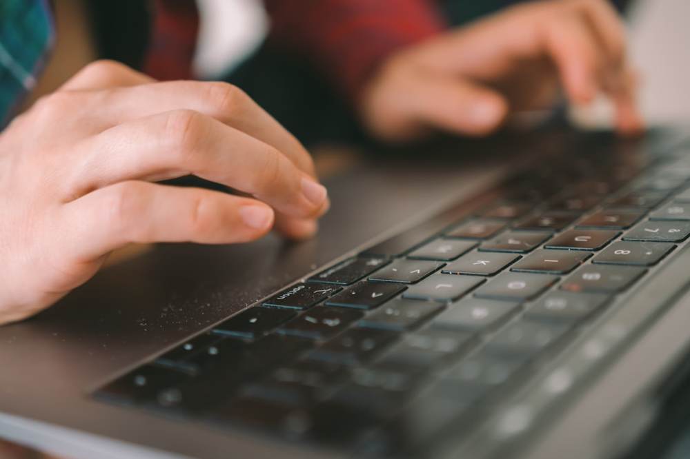 Meja kerja dengan laptop dan alat tulis sebagai ilustrasi ruang redaksi